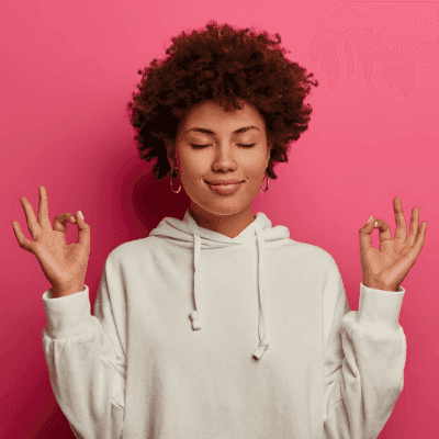 A woman with afro hair peacefully meditating on a vibrant pink background: Thumbnail